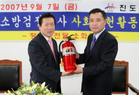 공사 남상호 사장(右)이 진도 이인곤 부군수(左)에게 소화기를 기증하고 있다.
