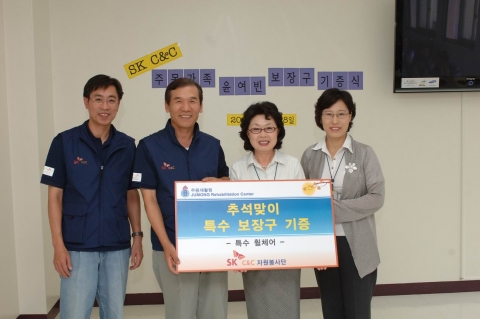 사진은 윤석경 SK C&C 사장(사진 왼쪽에서 두번째)이 장선옥 주몽재활원장(사진 왼쪽에서 세번째)에게 특수휠체어를 전달하고 기념촬영을 하는 모습