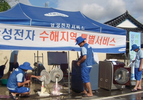 삼성전자가 태풍 나리로 수해를 입은 전남 고흥 서문 홍교에 이동서비스 차량을 동원한 수해복구 거점을 마련하고 수해를 입은 가구를 대상으로 전자제품 무상서비스와 함께 하우젠 드럼세탁