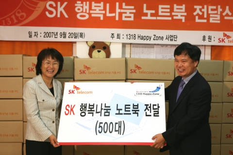 SK텔레콤 정보기술연구원장 박노철 전무가 이경림 1318해피존 사업단장에게 노트북을 전달하고 있다.