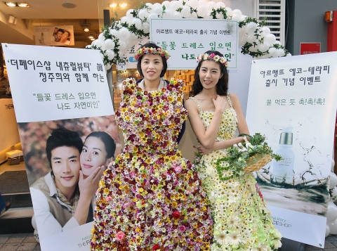 대만 여성 관광객이 9일 더페이스샵 명동 매장에서 열린 ‘아르쌩뜨 에코-테라피’ 라인 출시 기념 이벤트에서 더페이스샵이 뽑은 최고의 ‘자연미인’ 정주희와 함께 생화로 만든 들꽃 드레스를 입고 기념촬영을 하며 즐거워하고 있다.