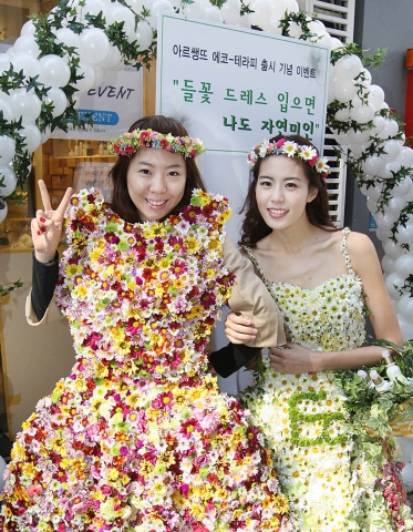 더페이스샵 명동 매장을 찾은 여성 고객이 9일 열린 ‘아르쌩뜨 에코-테라피’ 라인 출시 기념 이벤트 참여해 ‘더페이스샵 내추럴뷰티’ 진 정주희와 들꽃 드레스를 입고 포즈를 취하고 있다.