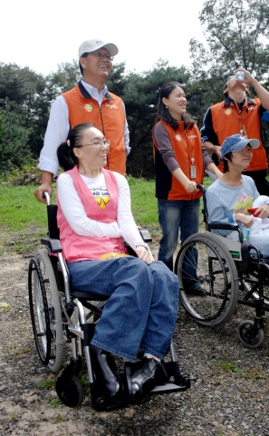 10일 하이닉스반도체 김종갑 사장이 이천 엘리엘 동산에서 장애우들과 함께 휠체어 산책에 나서고 있다.