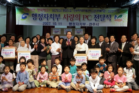 박명재 행정자치부 장관이 11일 서로 돕고 나누는 아름다운 조직문화 실현을 위하여 사랑의  PC 90대 등을 전달한 뒤 박수를 치며 기념촬영을 하고 있다.

