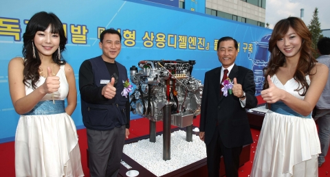 신형 F 3.9 엔진을 배경으로 왼쪽이 금속노조 현대차 지부 전주지회 김명선 지회장, 오른쪽이 전주 공장장 김영국 전무. 