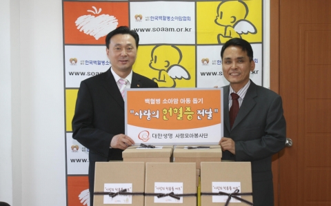 대한생명 사랑모아봉사단의 이은홍 홍보부장(사진좌측)이 18일 한국백혈병소아암협회(서울시 마포구)를 방문, 이철수 사무국장(사진우측)에게 헌혈증과 희망의 메시지, 학용품 세트를 전달
