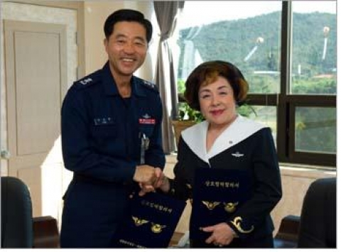 대한민국항공회 김경오총재와 공군본부 정책홍보실장 박상묵소장이 합의서에 서명한 후 손을 맞잡고 있다