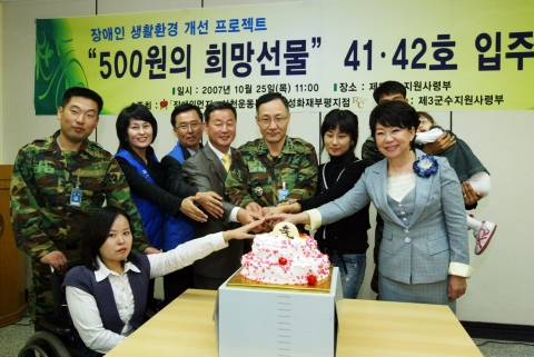 입주기념 케익을 커팅하고 있는 선정가족과 참석자들