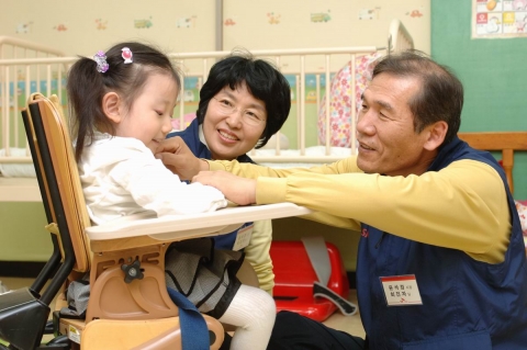 윤석경 SK C&C 사장(사진 오른쪽)과 부인 최진자씨가 김은지양(7세, 뇌병변1급)의 목욕을 도운후 함께 이야기 꽃을 피우고 있는 모습