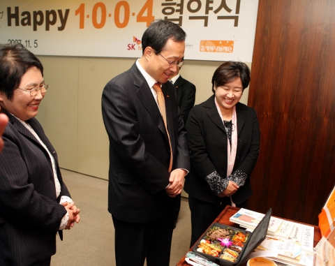 SK텔레콤 김신배과 굿네이버스 정금선 부회장 등 협약식 참석자들이 결식아동/청소년들에게 지급될 행복도시락 샘플을 살펴보고 있다.