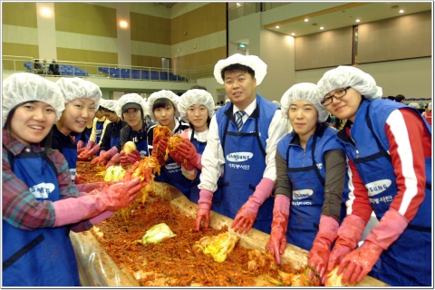 삼성전자 기흥사업장 임직원들과 자원봉사자들이 '사랑나눔, 김장축제'에 참가하여 김장김치를 담고 있다.