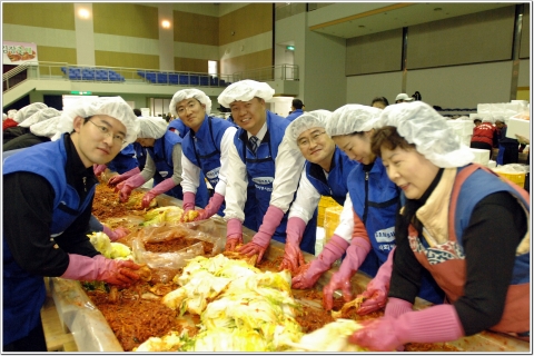 삼성전자 기흥사업장 임직원들과 자원봉사자들이 '사랑나눔, 김장축제'에 참가하여 김장김치를 담고 있다.