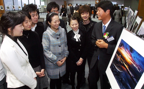 금상('염전의 석양') 수상자 김광석씨가(우) 관람객에게 작품을 설명하는 모습