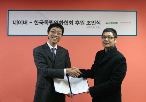 NHN㈜ 최재현 사업개발담당 이사(좌)와 (사)한국독립영화협회 임창재 이사장이 조인서에 서명 후 악수를 나누고 있다.