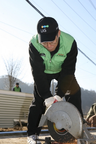전기톱을 이용해 건축 자재를 자르고 있는 LIG손해보험 김우진 사장