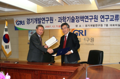 STEPI 정성철 원장(우)와 GRI 좌승희 원장(좌)이 협약 체결 후 협정서를 교환하고 있다.