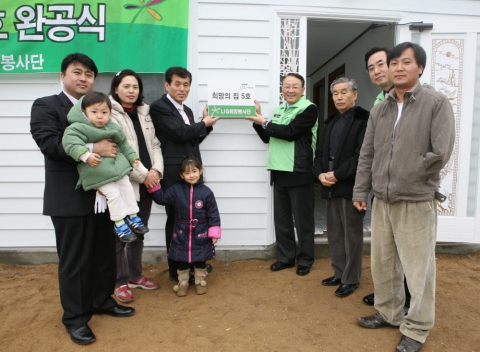 LIG손해보험이 12일 강원도 양구에서 가진 ‘희망의 집’ 완공식에서 구자준 부회장(우측 네번째)과 예민이(좌측 다섯번째)네 가족, 김대영 양구 부군수(좌측 네번째), 이창수 한국복지재단 강원본부장 등과 함께 현판을 걸고 있다.