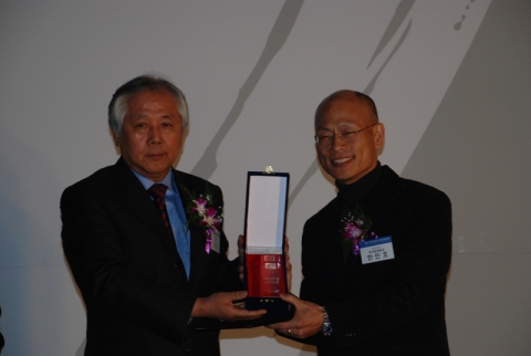 사진은 오인욱 회장으로부터 문화관광부 공간문화팀장이 상패를 받고 있는 모습