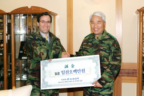 리처드 웨커 외환은행장이 백군기 육군 제3군사령관에게 성금을 전달하고 있다.