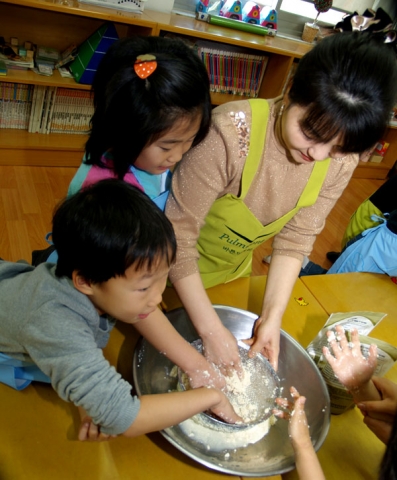풀무원 봉사자와 ‘서대문 종합 사회 복지관’내 공부방 어린이들이 함께 두부를 이용해 설기를 만들며 즐거운 하루를 보내고 있다.