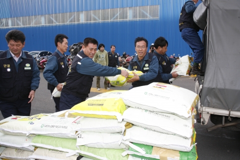 현대중공업 노동조합 오종쇄 위원장(가운데 안경)이 취임 선물로 받은 쌀을 무료급식소에 전달하기 위해 트럭에 싣고 있다.