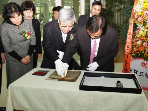 12월 26일 경상대학교 중앙도서관 1층 로비에서 열린 &#039;장서 100만권 확보 및 도서관 리모델링 오픈식&#039;에서 하우송 총장(왼쪽)과 100만 권째 도서를 기증한 하동 북천증학교 최증수 선생이  ‘복재유고(復齋遺稿)’에 날인을 하고 있다.