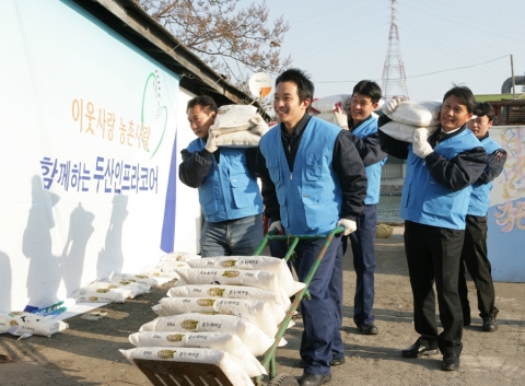 설을 맞이하여 두산인프라코어 임직원들이 인천공장 주변 불우이웃들에게 쌀을 전달하는 이웃사랑 활동을 펼치고 있다.