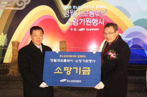 르노삼성자동차 장마리 위르띠제 사장이 13일 진행된 정월대보름 소망기원행사에서 김충용 종로 구청장에게 소망 기금을 전달하고 있다.
