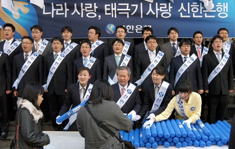 신상훈 은행장이 청소년등 일반시민들에게 태극기를 나눠주는 모습