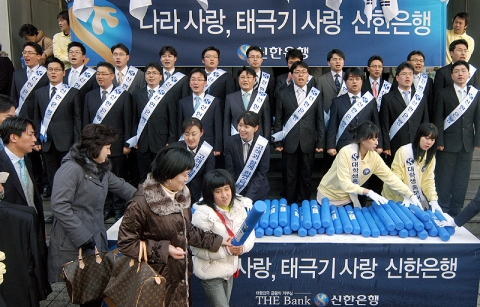 신한은행 직원과 대학생홍보대사가 태극기를 나눠주는 모습