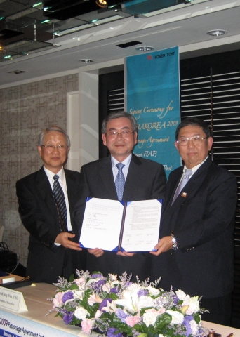 우정사업본부 정경원본부장(가운데)과 FIAP(아시아우취연맹) 수라짓 공보타니 회장(오른쪽), 한국우취연맹 김장환 회장이 9일 타이베이에서 ‘필라코리아 2009 아시아국제우표전시회’ 후원 협정서를 펼쳐 보이며 환하게 웃고 있다.