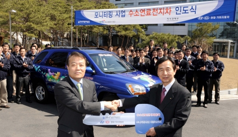 25일 현대기아차 선행기술센터장 조원석 전무(사진 왼쪽)가  스포티지 연료전지차 차량 인도식에 앞서 에너지관리공단 구종덕 부 이사장에게 차량 키를 전달하고 있다.