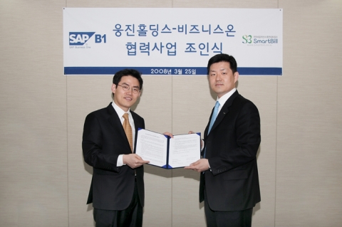 웅진홀딩스 사옥에서 열린 조인식에서 비즈니스온의 김계원이사(좌측)와 웅진홀딩스의 이재진상무가 서류를 교환하고 있다