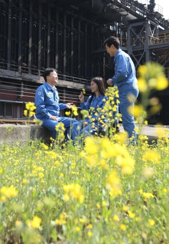 직원들이 휴식시간에 유채꽃밭에서 담소를 즐기고 있다.