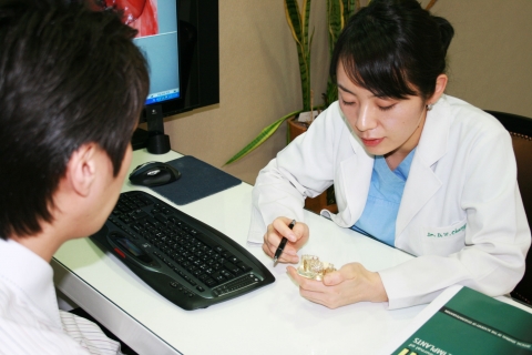 고객약속 켐페인을 시작한 모아치과네트워크의 정다운 원장이 환자에게 자세한 치료과정을 설명해주고 있다.
