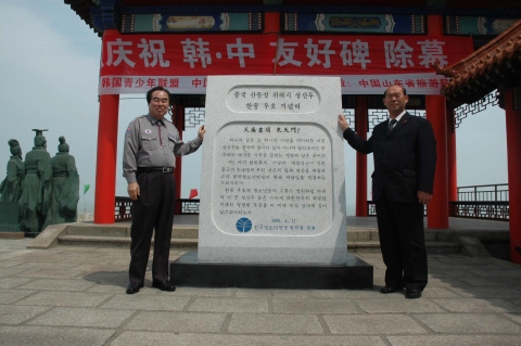 한국청소년연맹 차종태 총재(左)와 서하구 그룹 여유공사 전서경 총경리(右)가 이번에 건립한 「한중 우호 기념비」앞에서 포즈를 취하는 모습