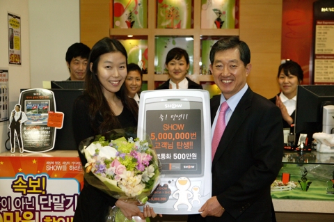 KTF 조영주 사장이 SHOW 5백만 번째 고객인 양나들 氏에게 축하꽃다발과 5백만원 상당의 무료통화권을 전달하고 있다.