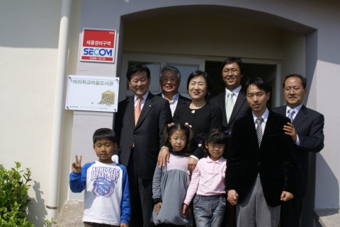 제주 가파초등학교 마라분교 학생들과 선생님, NHN 최휘영 대표 (뒷줄 오른쪽), (사)작은도서관만드는사람들 김수연 대표(뒷줄 왼쪽) 등이 59번째 네이버 마을도서관 개관 현판식을 갖고 기념촬영을 하고 있다.