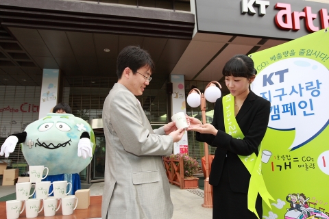 KT 광화문지사 앞에서 지구의날을 맞아 종이컵 대신 머그컵 사용을 권장하기 위해 ''KT지구사랑 캠페인''을 통해 머그컵을 나눠주고 있다.