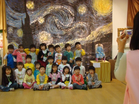 빈센트 반 고흐의 자화상인형(윤리나작)이 지켜보는 가운데 어린이들이 고흐작&lt;별이 빛나는 밤&gt;의 대형설치미술앞에서 기념사진을 찍고 있다.