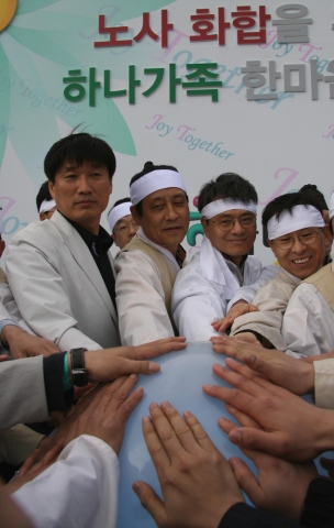 26일 용인 에버랜드에서 열린 노사화합을 위한 '하나가족 한마음 잔치'에서 하나은행 임원과 노조간부들이 오색풍선 발사 버튼에 손을 맞대고 있는모습임. (왼쪽부터 하나은행 김창근노조위원장, 김정태행장, 이우공부행장보)