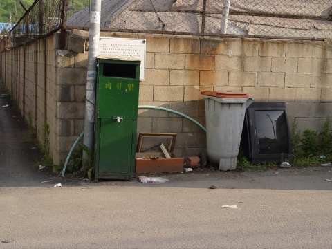의류수거함 주변에 무단투기된 TV와 연탄재