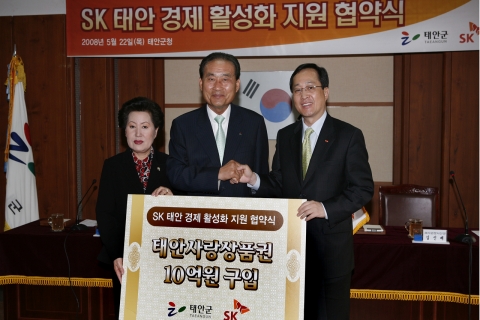 김신배 SK텔레콤 사장(오른쪽)이 22일 충남 태안군청에서 진태구 태안군수(가운데), 이용희 태안군의회 의장(왼쪽)과 함께 'SK 태안 경제활성화 지원 협약식'을 체결한 뒤 악수하고 있다.