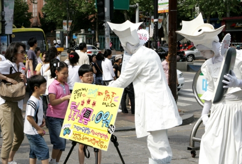 LG데이콤은 지난 25일 대학로와 신촌 등 대학가에서 인터넷 집전화 myLG070을 주제로 한 마임 퍼포먼스를 펼쳤다. myLG070폰을 든 퍼포머들이‘120분 째 통화중, 통화요금은 무료’라는 내용의 안내판을 사이에 두고 행인들과 기념 촬영을 하고 있다.