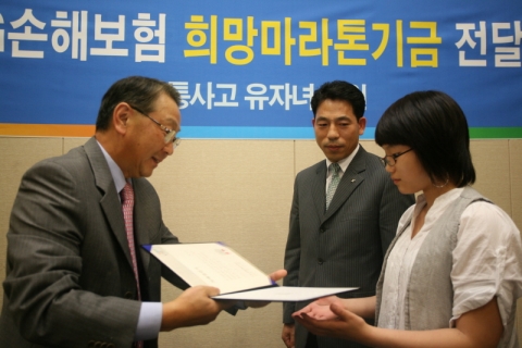LIG손해보험 구자준 부회장(왼쪽)이 교통사고유자녀에게 장학증서를 전달하고 있다.