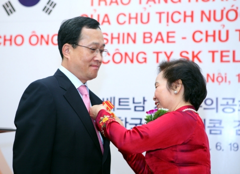 김신배 사장과 응웬 티 조안 베트남 국가 부주석이 "국가우호훈장" 증서를 들고 포즈를 취하고 있는 장면.