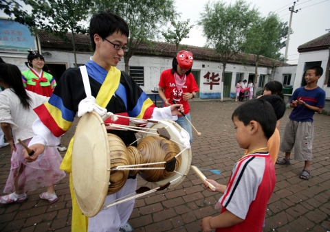써니 대학생자원봉사자가 중국 학생들에게 장구연주법을 알려주고 있다.