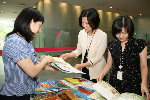 LG CNS 임직원들이 상암 IT센터에서 열린 ‘만원의 행복 바자회’에 참가해 자녀를 위한 도서를 고르고 있다.