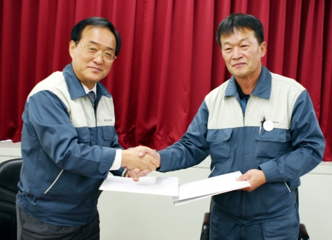 현대엘리베이터 송진철 사장(좌측)과 성용주 노조위원장(우측)이 금년도 임금협상에 합의후 합의서를 교환하고 악수하는 모습