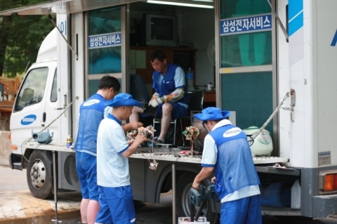 폭우로 수해를 입은 경북 봉화군 춘양면 서벽1리 서벽초등학교에서 삼성전자 수해 특별서비스팀이 이동차량에서 침수로 피해를 입은 가전제품 무상 서비스를 하고 있다.